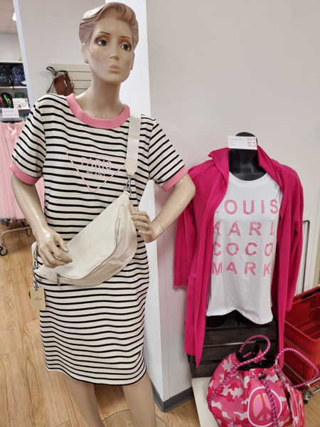 Zwei Schaufensterpuppen präsentieren modische, lässige Kleidung in Rosa, Schwarz und Weiß.