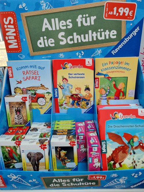 Verkaufsdisplay mit bunten Kinderbüchern und Spielen für die Schultüte, Preis 1,99 €.