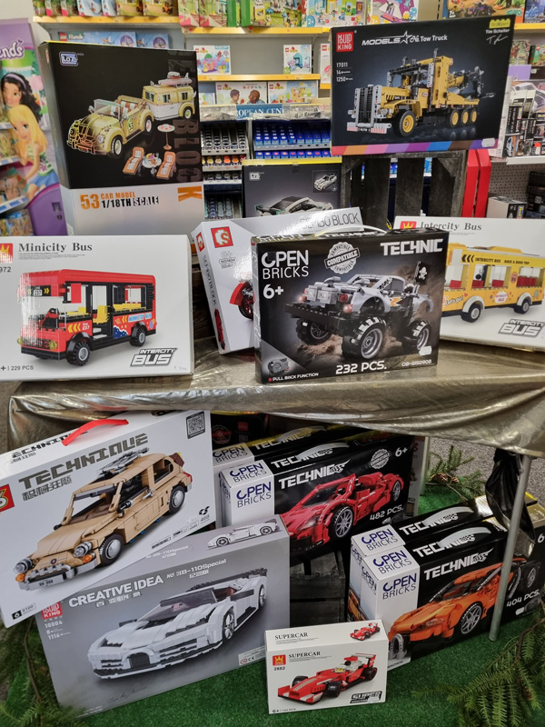 Bunte Bausatzverpackungen von Fahrzeugen in einem Spielwarengeschäft auf einem glänzenden Tisch.