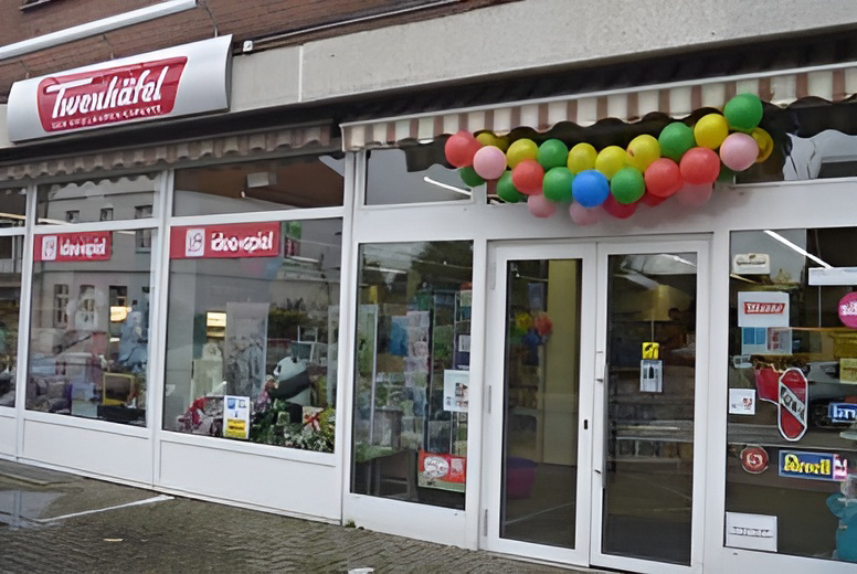 Ein Laden namens "Twenhäfel" mit bunter Luftballondekoration und einer einladenden Glasfront.