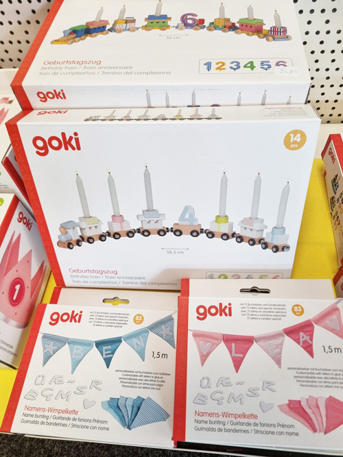Bunte Geburtstagszüge und Namens-Wimpelketten von goki, ausgestellt in einem Geschäft.